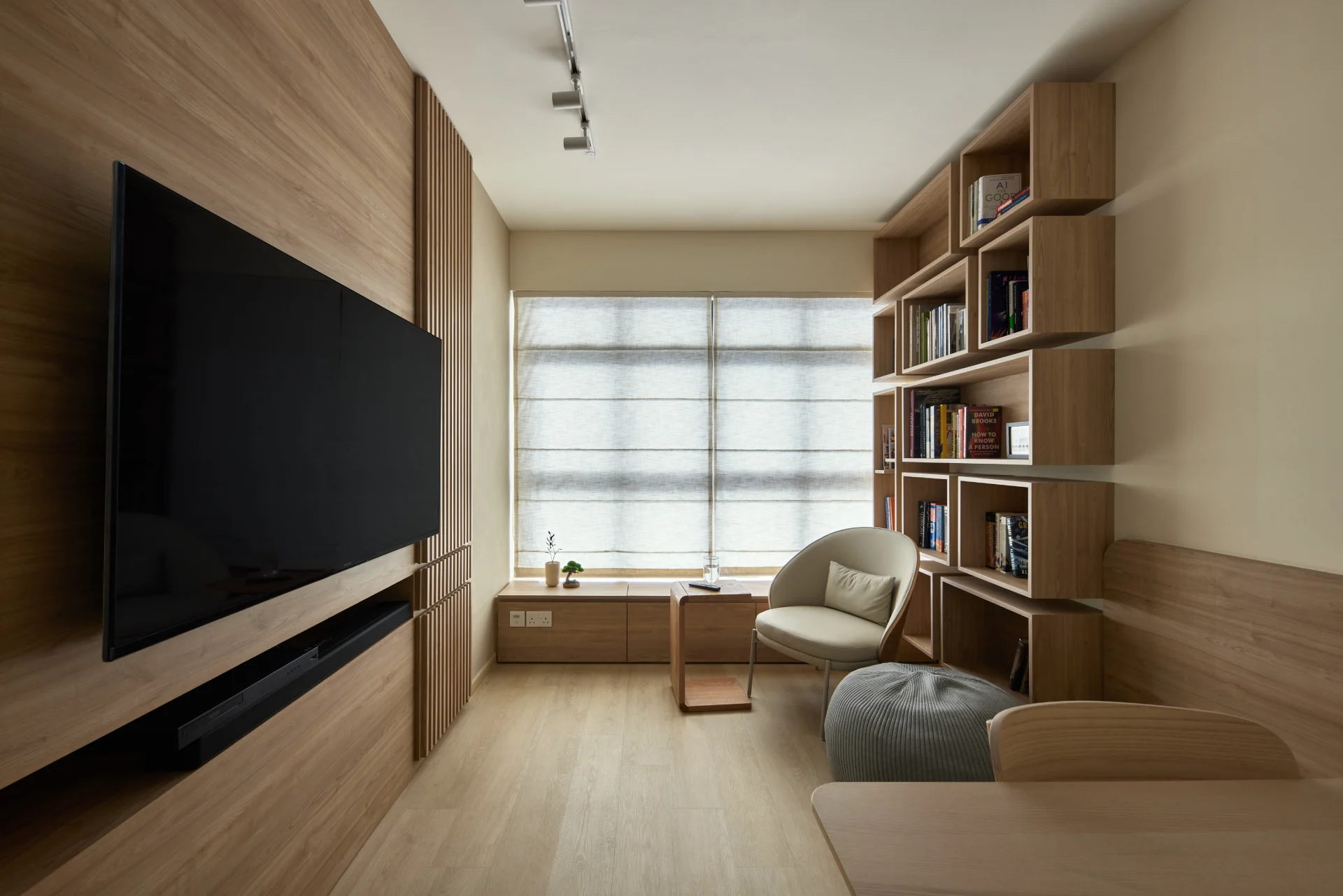 Modern minimalist living room with wood panel TV wall, built-in shelving, and natural light