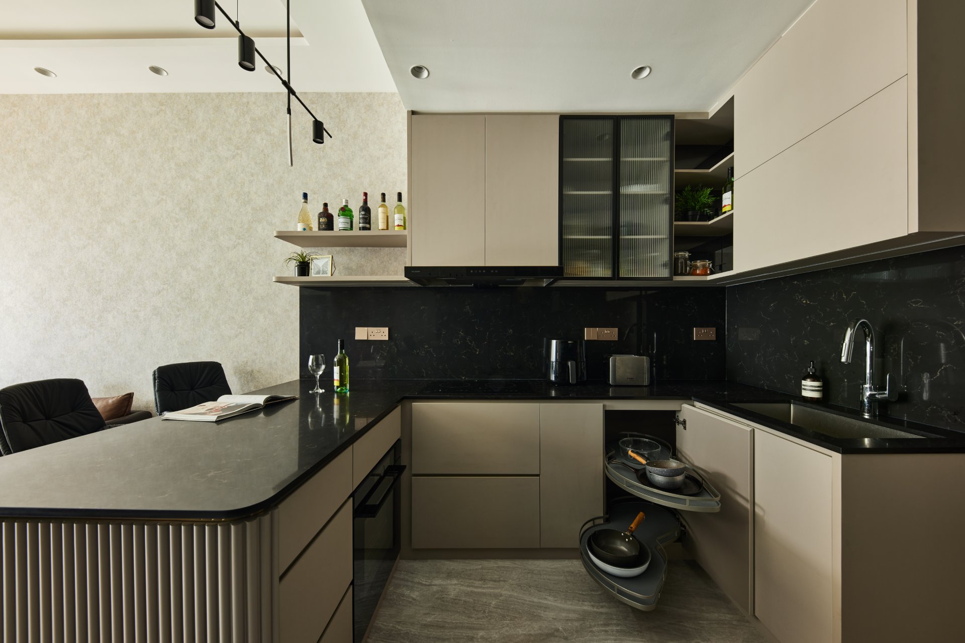 Modern kitchen with dark countertops, light brown cabinets, and integrated corner storage