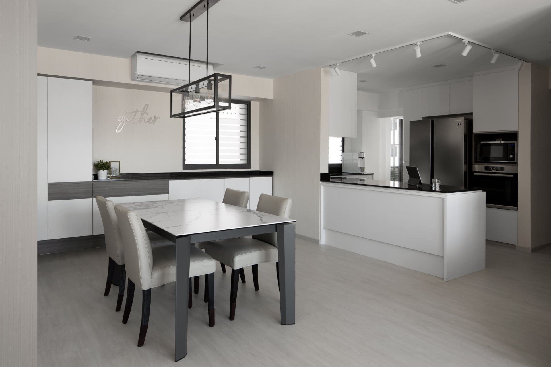 Modern kitchen and dining with white island, wood accents, and sleek appliances