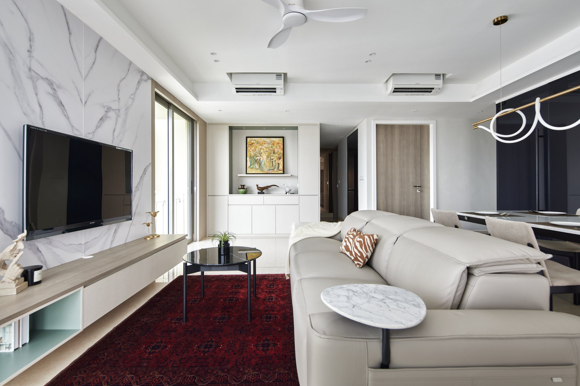 Luxury living room with white marble feature wall, light grey leather sofa, and red patterned rug