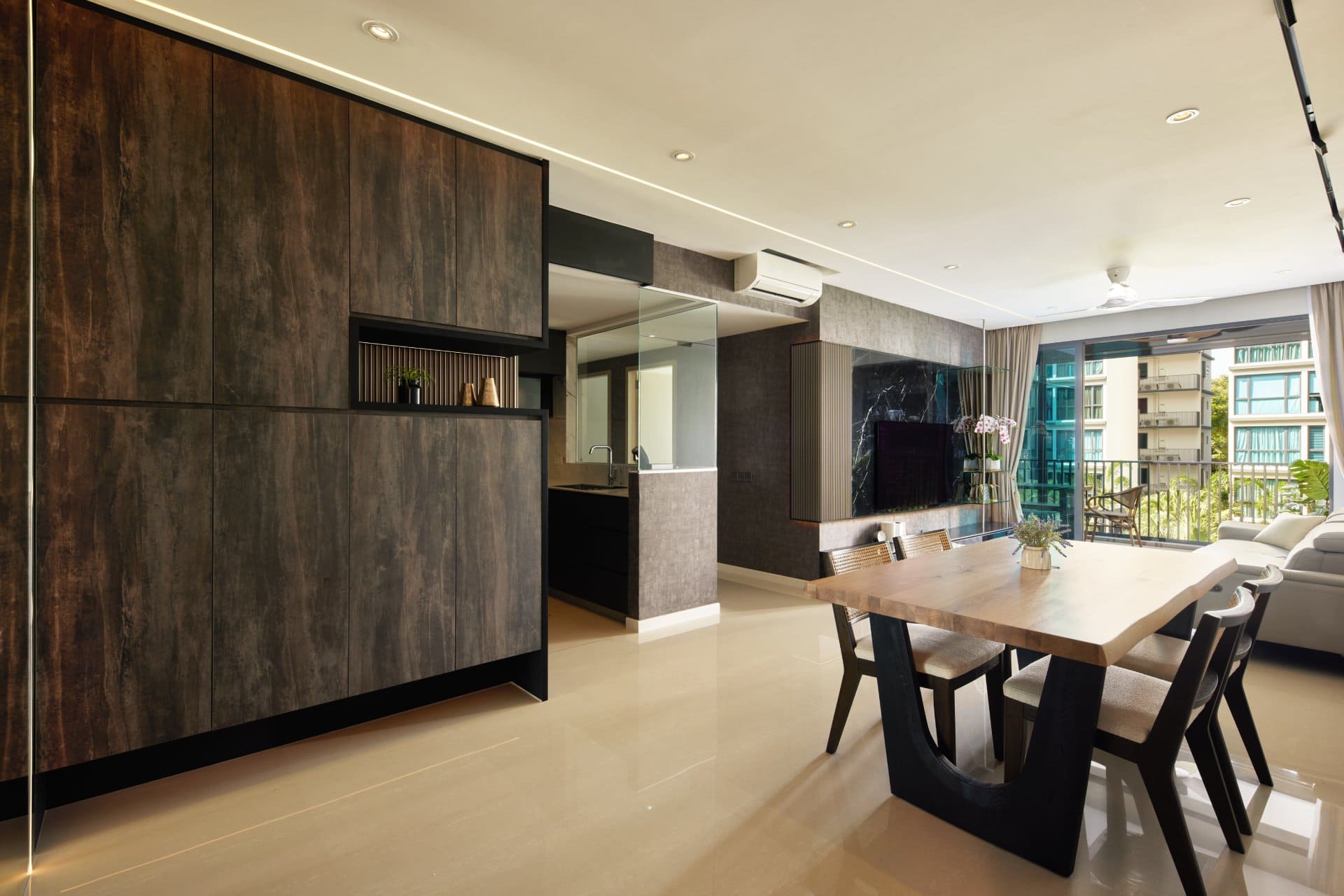 Modern living room with a large live-edge wood dining table, black chairs, and a sleek TV wall with marble accents and integrated lighting