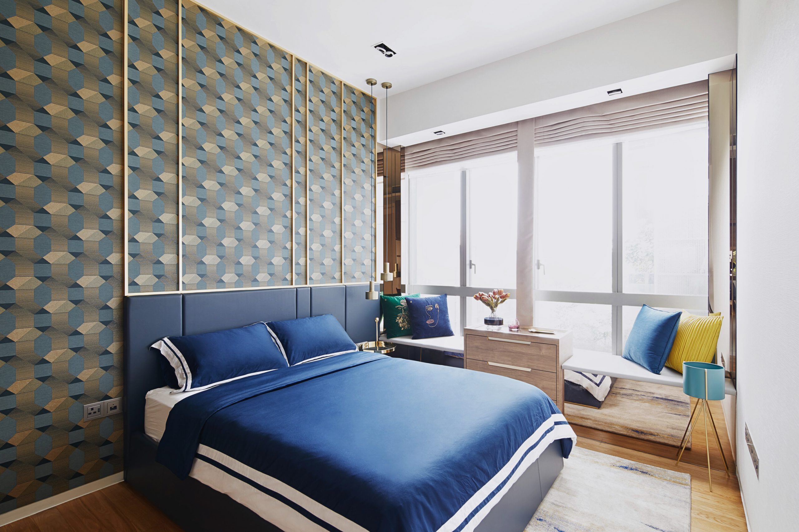 Modern condo master bedroom with blue patterned feature wall and window seating
