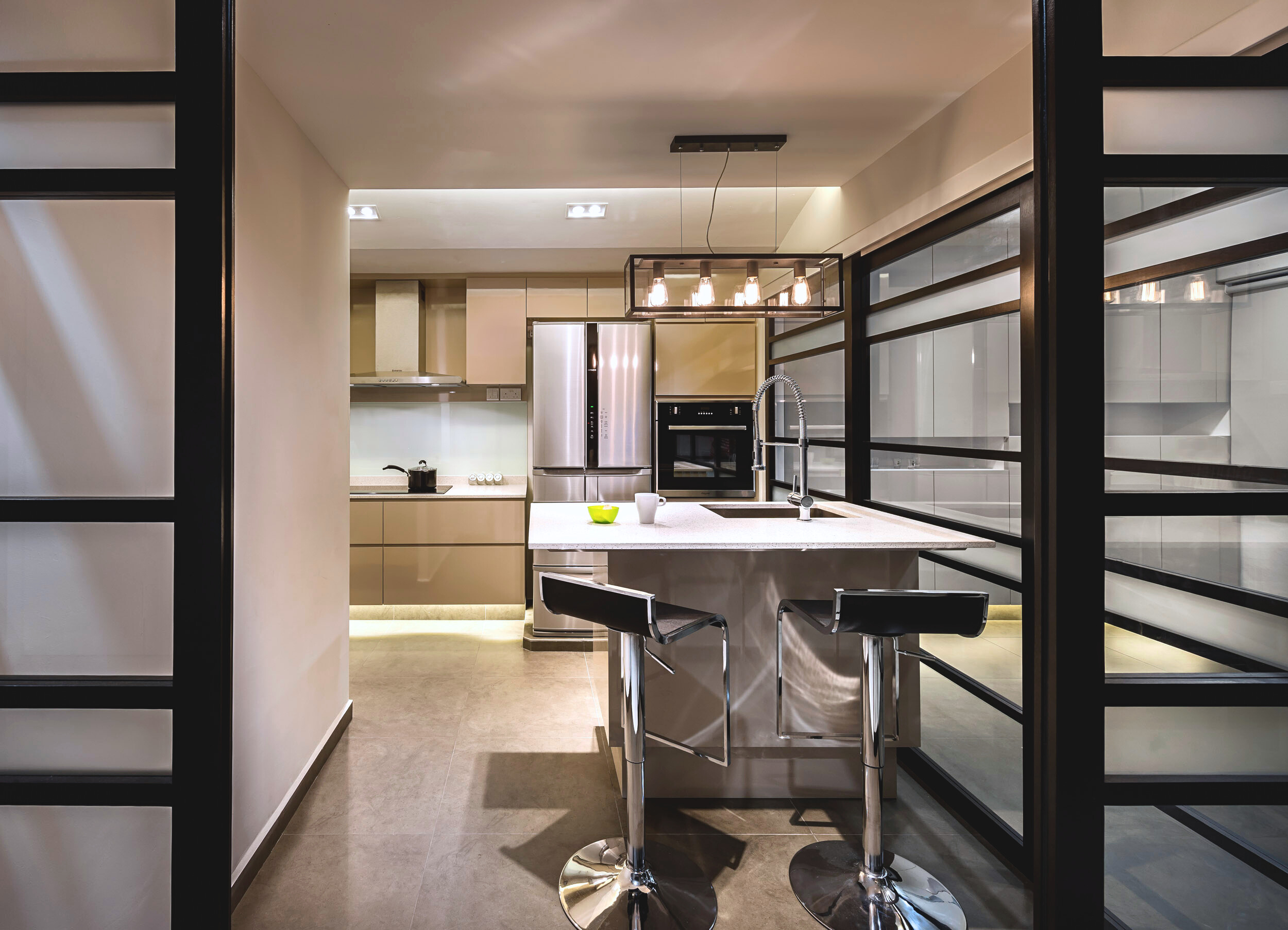 Kitchen with island counter framed by black aluminium glass panels.