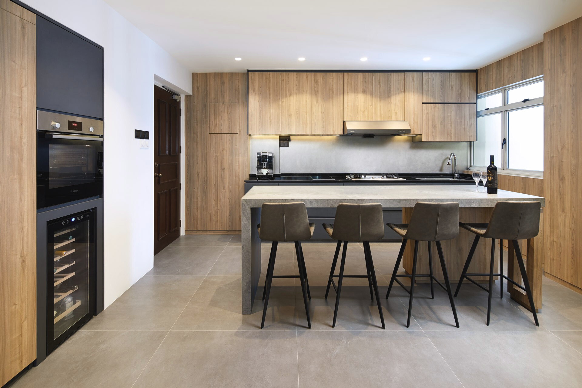 Modern kitchen with large island, wood cabinetry, and neutral grey flooring.