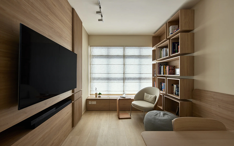 Cozy Japandi living room with wooden wall panels and bookshelves.