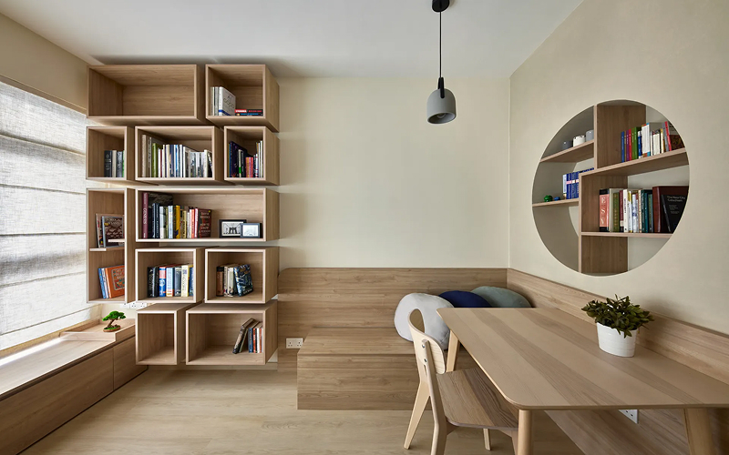 Japandi living room with wooden wall panels and bookshelves.
